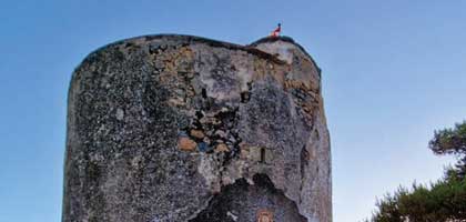 L'immagine rappresenta la parte alta di una torre circolare con sfondo cielo